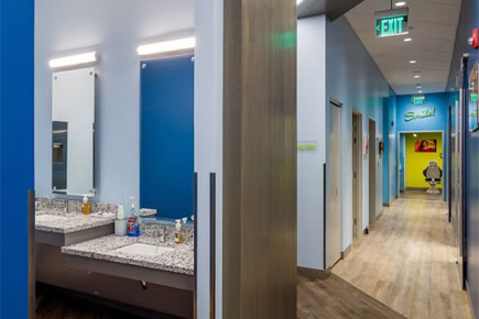 Modern orthodontic office hallway with blue accent walls and treatment rooms.