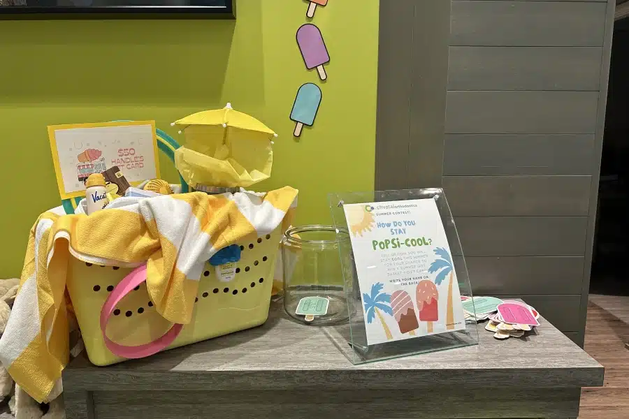 Orthodontic office display featuring yellow promotional materials, children's toys, and informational brochures on desk.